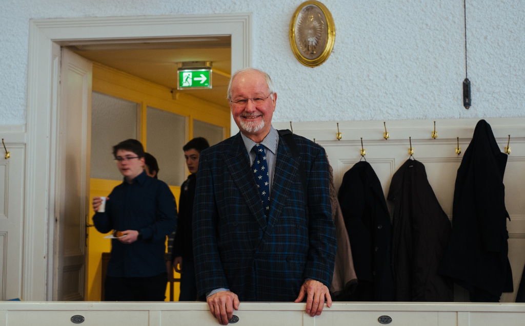 Die Gäste der Matinee fühlen sich im historischen Ambiente des Christian-Doppler-Hörsaals sehr wohl. Im Hintergrund eine Messing-Wandleuchte und die zaponierten Messing-Kleiderhaken.