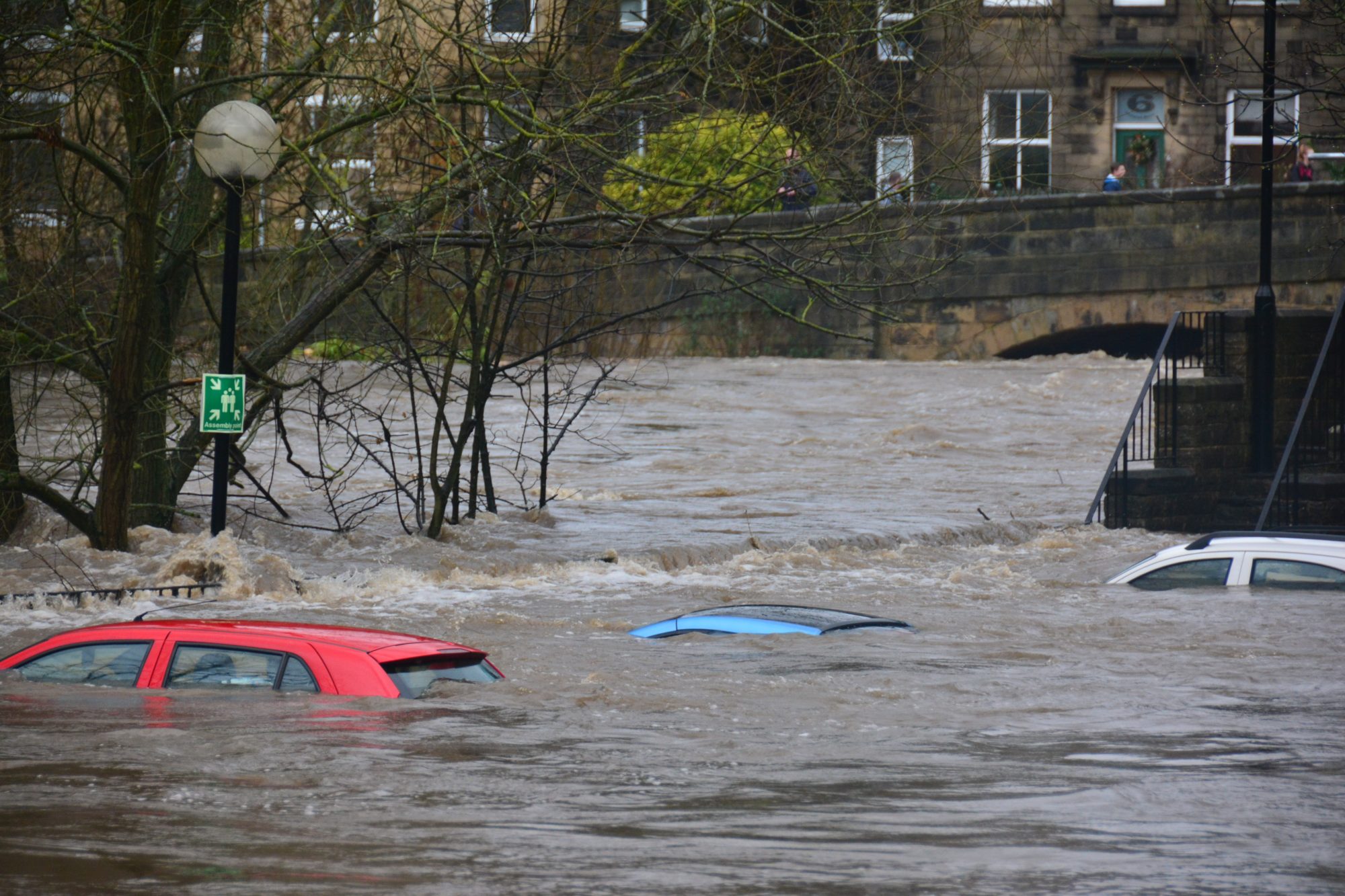 Eine Straße, Autos und Häuser stehen unter Wasser.