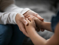 Eltern und Kind halten sich die Hände