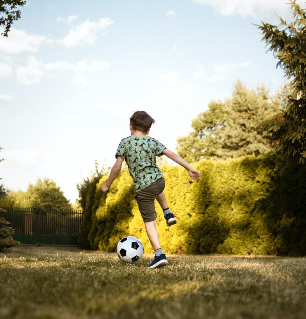 Junge am Fußball spielen