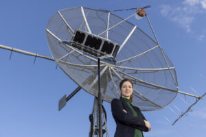 Systemingenieurin Manuela Wenger steht vor einem Satelliten.