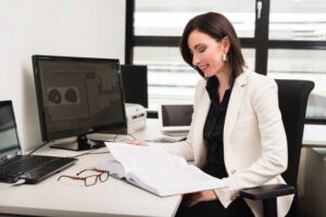 Neurowissenschafterin Manuela Macedonia sitzt an ihrem Schreibtisch und studiert ein Buch.