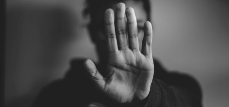 Eine Frau zeigt ihre ausgestreckte Handfläche nach vorne.