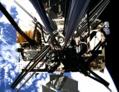 Eine Sonde im Weltraum, dahinter die Erde.