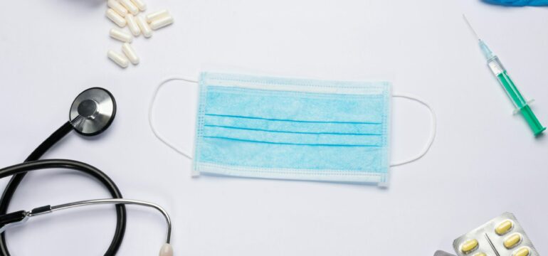 Eine Maske, eine Spritze, Handschuhe, Tabletten und ein Stethoskop.
