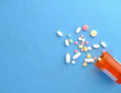 Verschiedene Tabletten fallen aus einer Dose.