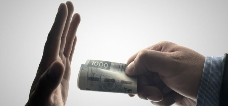 Eine Hand hält einen Geldschein, eine andere Hand lehnt diesen ab.